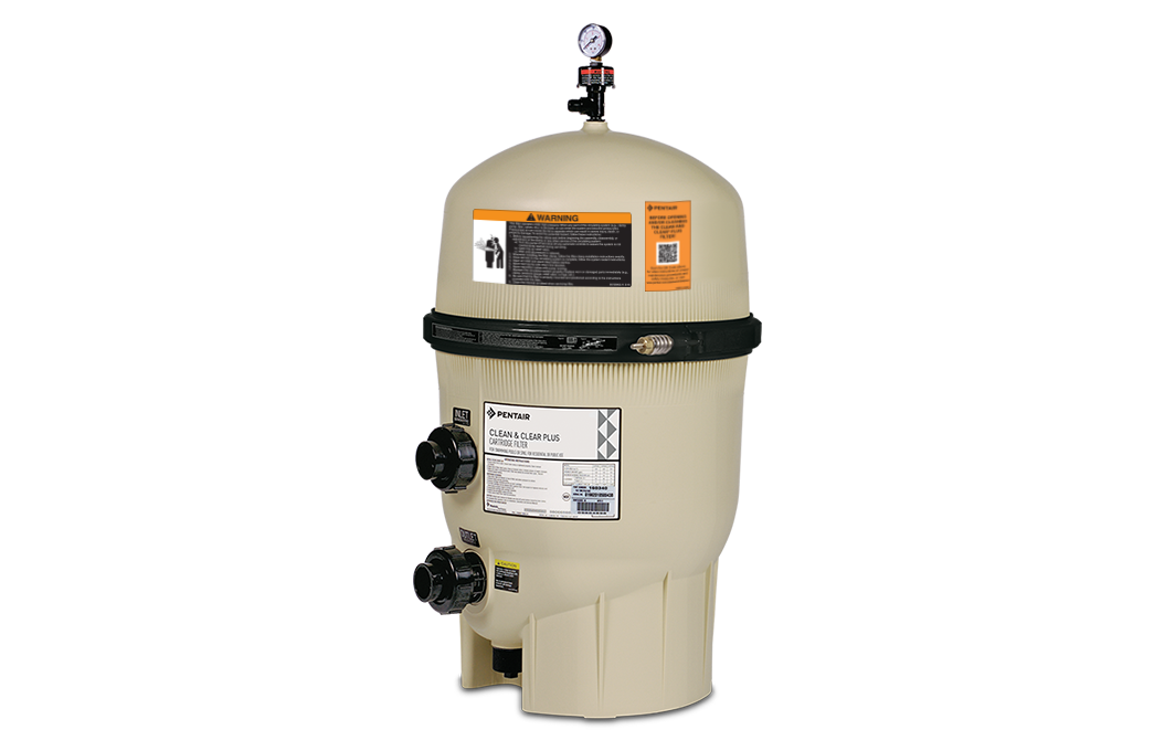 Beige pool filter tank with pressure gauge on top, multiple pipe connections, and several warning and information labels on its body.